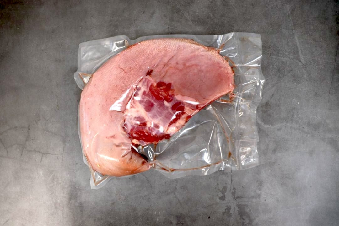 Vacuum-sealed ham on a gray surface
