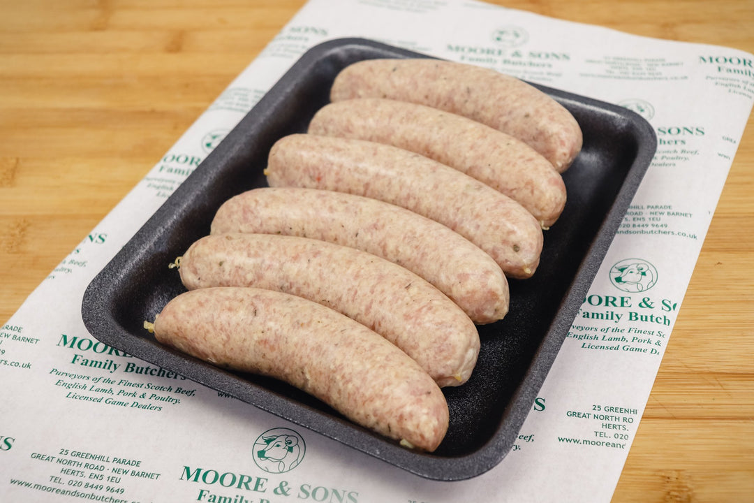 six chicken sausages on a tray on top of a butchers block