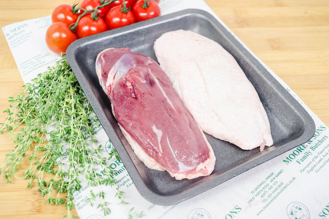 barbary duck breasts on a tray with tomatoes and herbs on the side