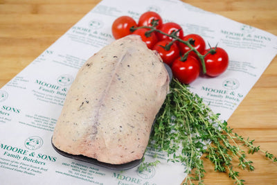 mallard on a butchers block with tomatoes and herbs on the side