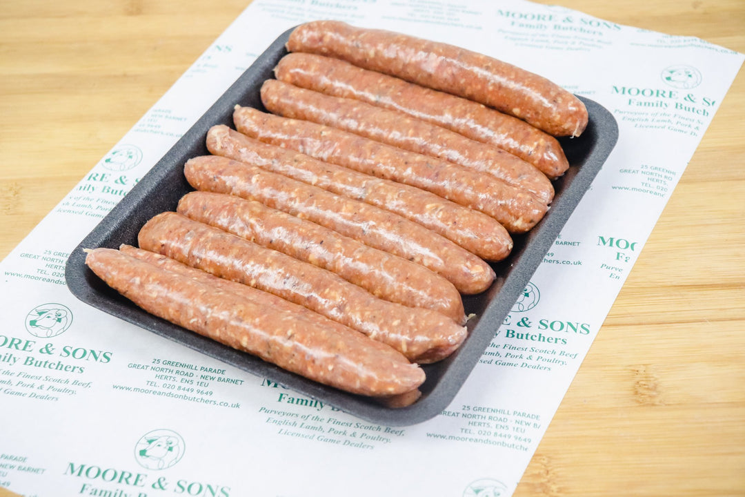 ten merguez sausages on a black tray on top of a butchers block