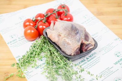 pigeon on a tray with tomatoes and herbs on the side