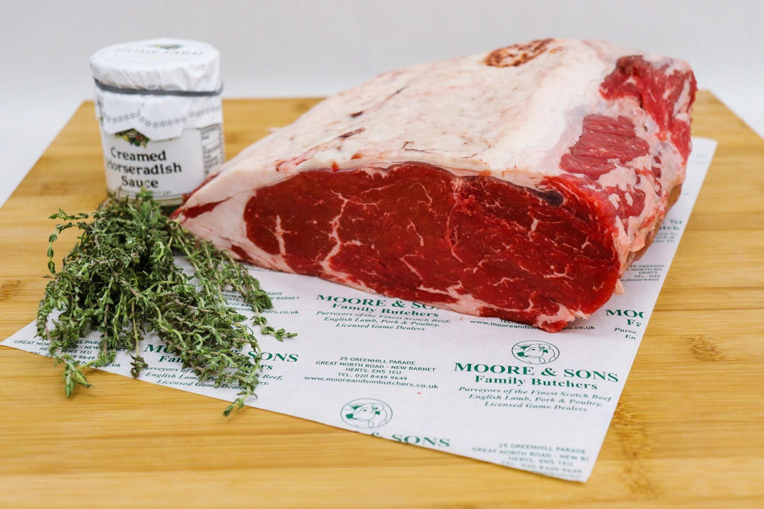 sirloin on a butcher block with herbs and creamed horseradish sauce on the side