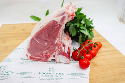 veal chop on a butchers block with tomatoes and herbs on the side